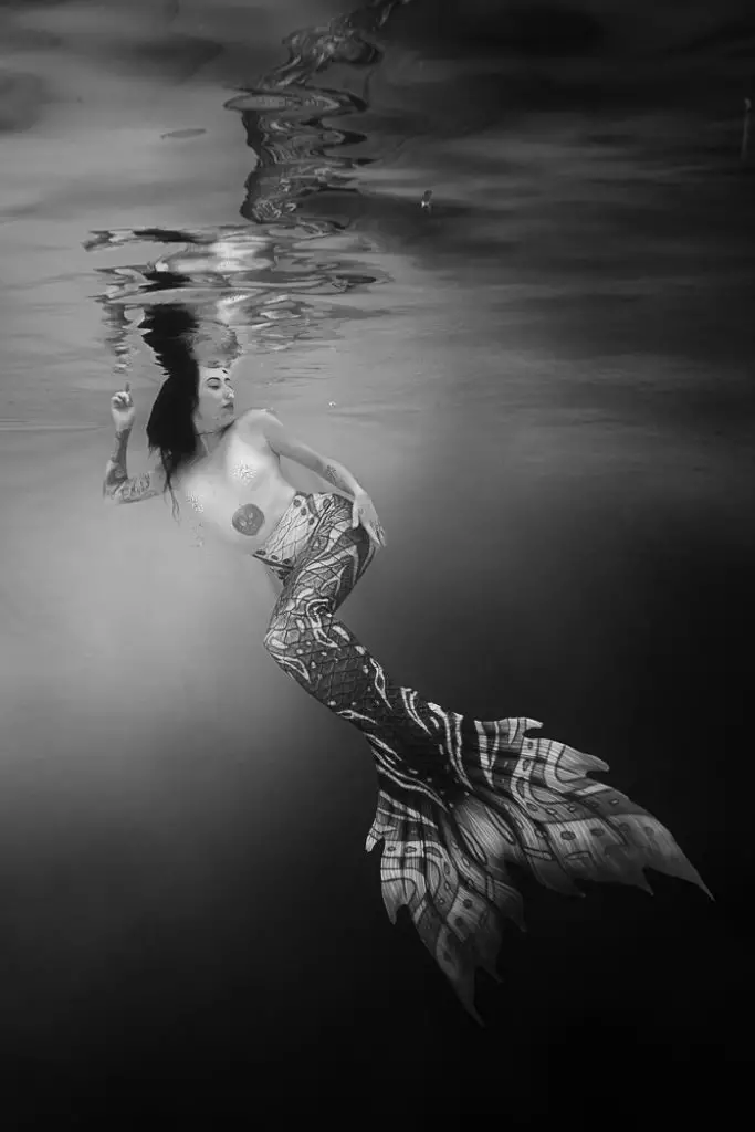black and white image of a woman in a mermaid tail